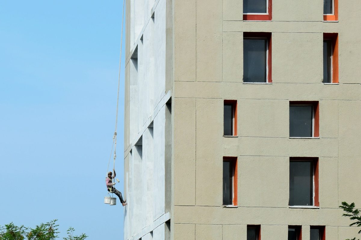 Maler streicht eine Hausfassade